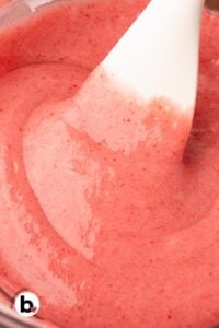 Smooth and creamy strawberr glaze for pastries in a mixing bowl.