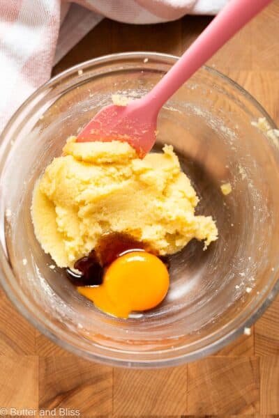 Creamed butter and sugar in a mixing bowl with an egg yolk.