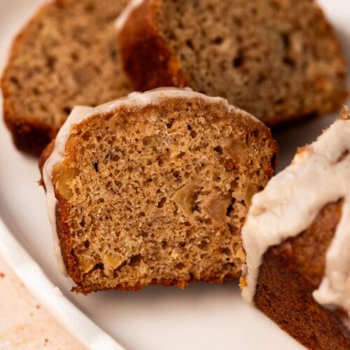 Apple banana bread mini loaf cut into slices on a white plate.