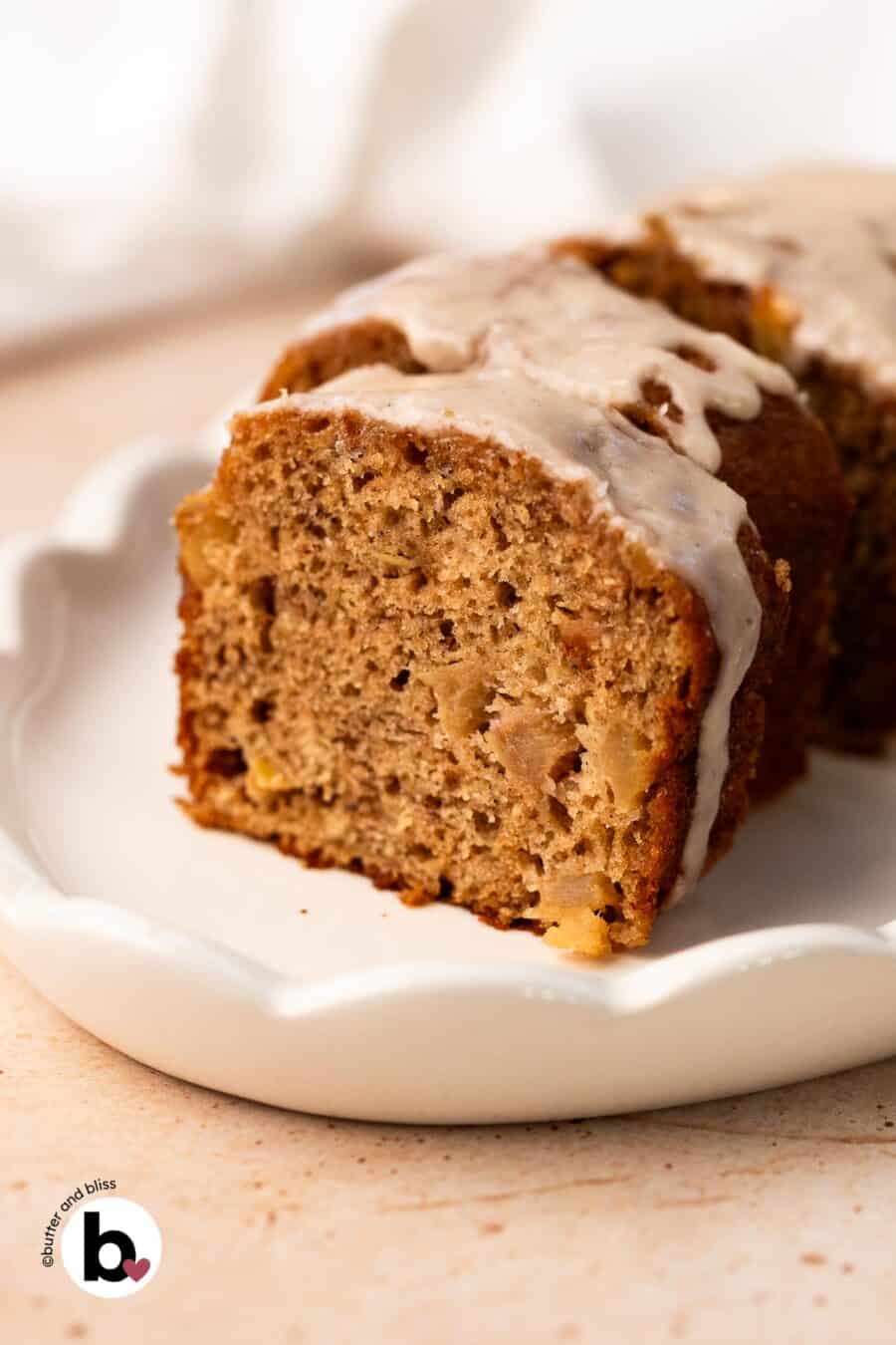 Slice of small apple banana bread loaf revealing moist crumb and apple chunks.