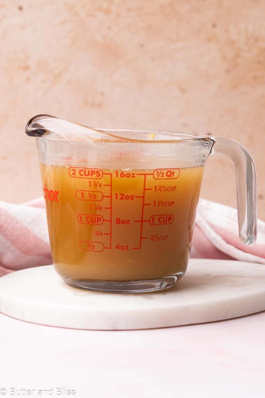 Ginger syrup in a glass measuring cup.