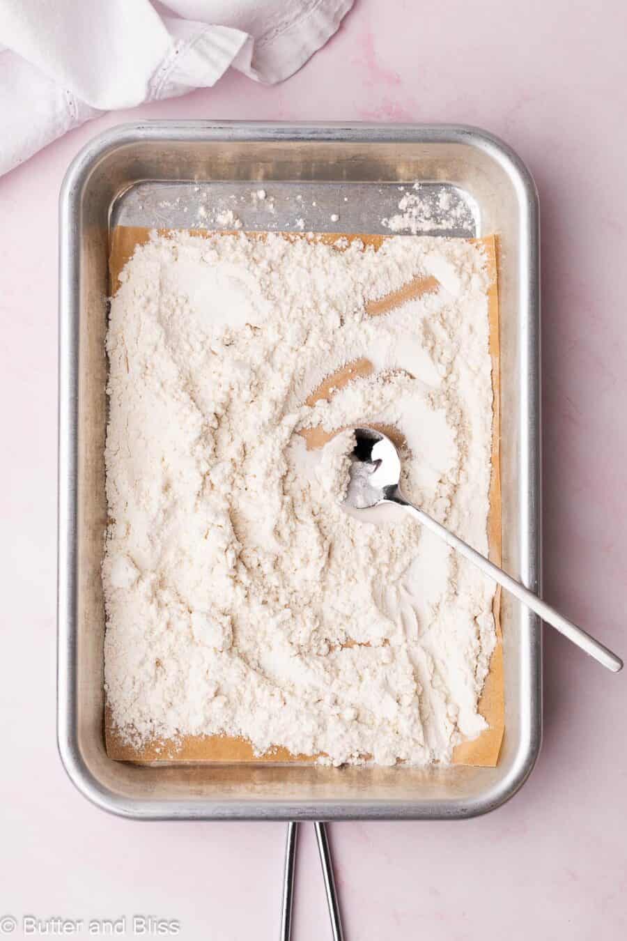 heat-treated flour spread on a small baking sheet with a spoon.
