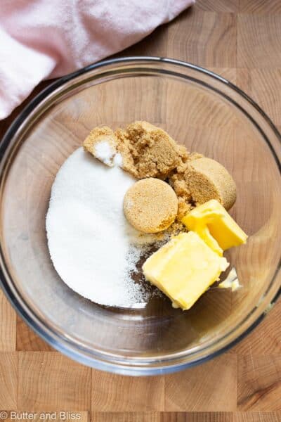 Butter and sugar in a mixing bowl with a pink napkin.