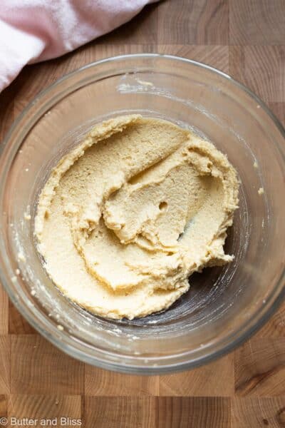 Creamed butter and sugar in a mixing bowl with a pink napkin.