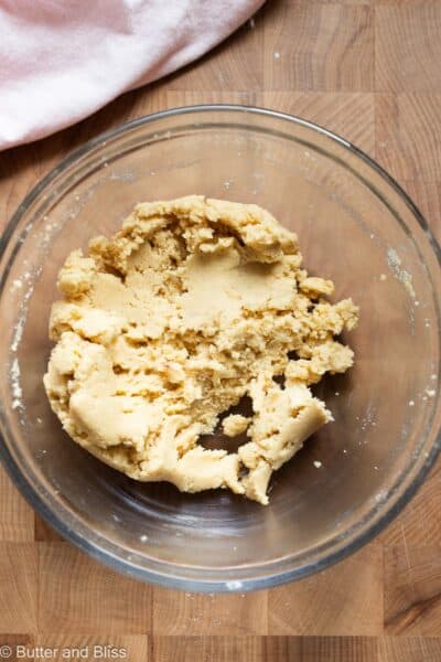 Thick cookie dough in a mixing bowl with a pink napkin.