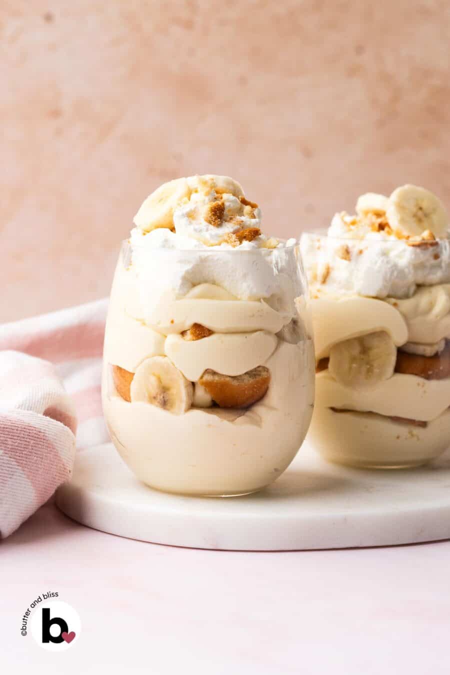 From scratch creamy banana pudding layered in two parfait glasses.