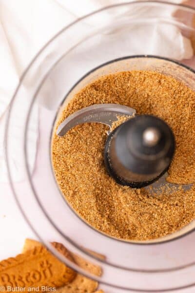 Graham cracker and Biscoff cookie crumbs in a food processor.