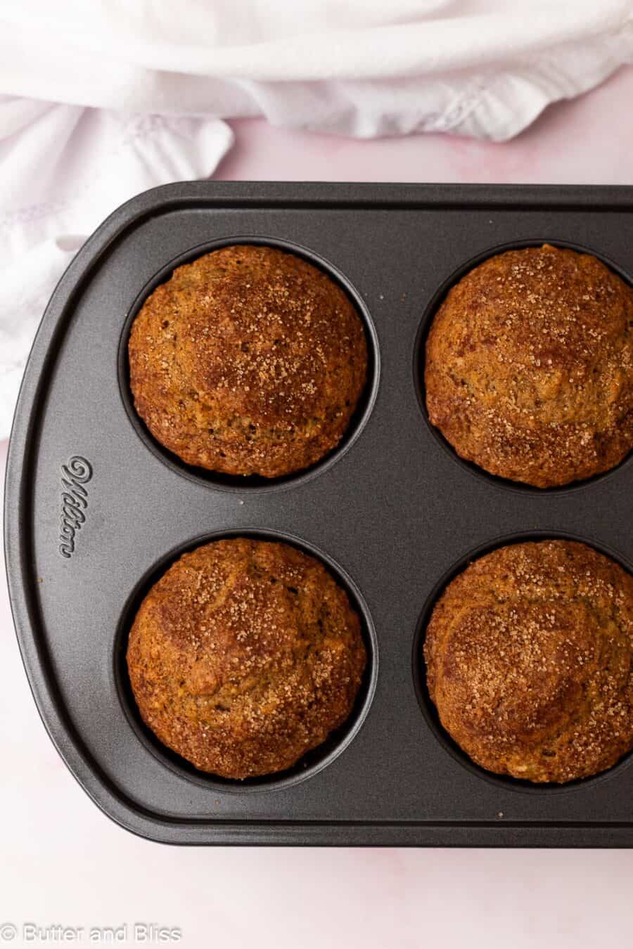Fresh from the oven small batch banana muffins in a muffin tin next to a white napkin.