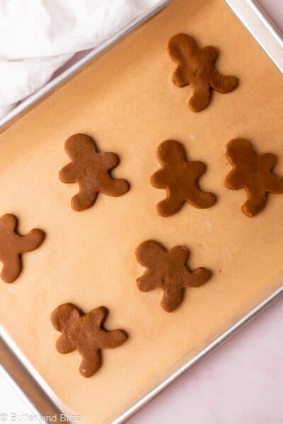 Gingerbread man cookies on a parchment lined baking sheet, redy to be baked.