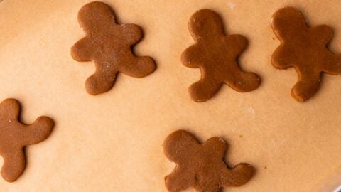 Gingerbread man cookies on a parchment lined baking sheet, redy to be baked.