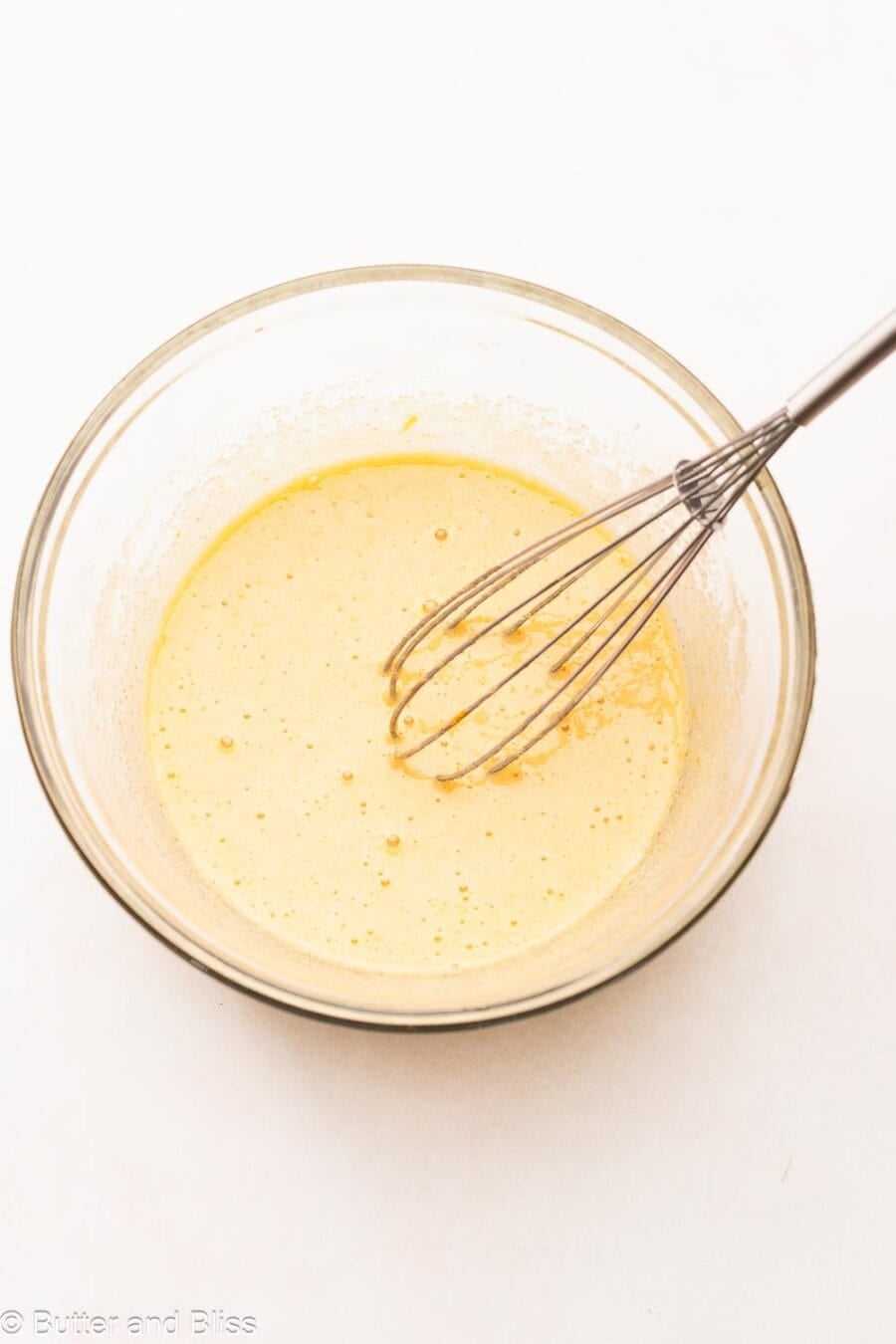 Egg and sugar mixed until foamy in a mixing bowl with a whisk.