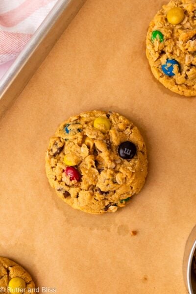 Perfectly round monster cookie, freshly baked on a cookie sheet.