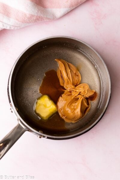 Peanut butter and butter added to a small saucepan of melted sugar.