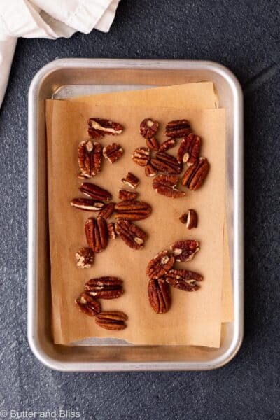 Toasted pecans on a small baking sheet.