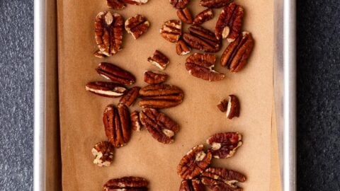 Toasted pecans on a small baking sheet.