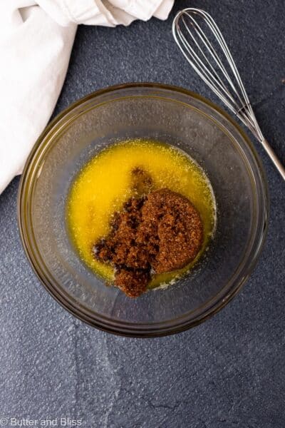 Brown sugar and melted butter in a small mixing bowl, about to be whisked.