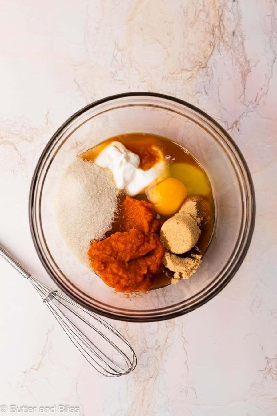 Wet ingredients for pumpkin muffins in a mixing bowl.