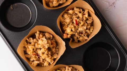 Apple pumpkin muffins covered generously in streusel in a muffin pan.