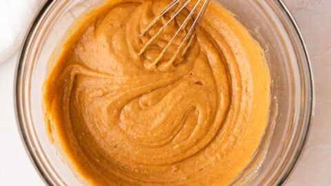 Pumpkin batter in a mixing bowl with a whisk.