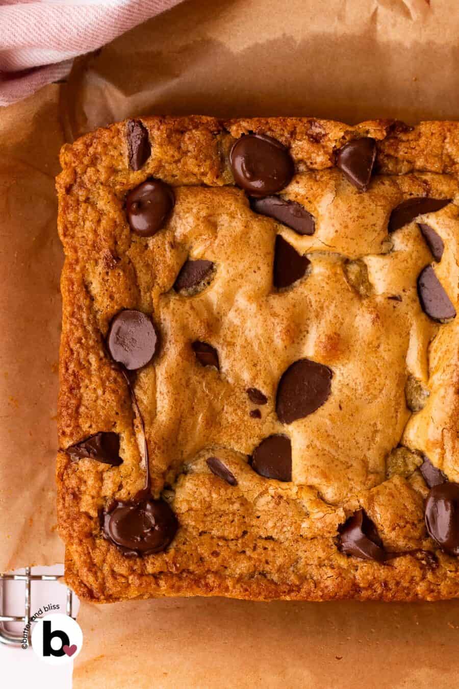 Fresly baked small batch blondies, before being cut into squares, on parchment paper.