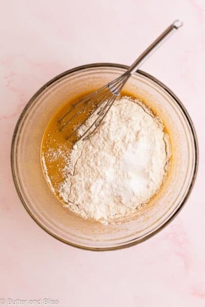 Dry ingredients sifted over wet blondie ingredients in a small mixing bowl.