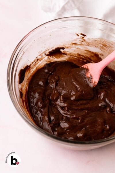 Bowl of fudgy chocolate crinkle cookie dough with a pink spatula.