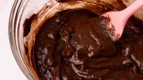 Bowl of fudgy chocolate crinkle cookie dough with a pink spatula.