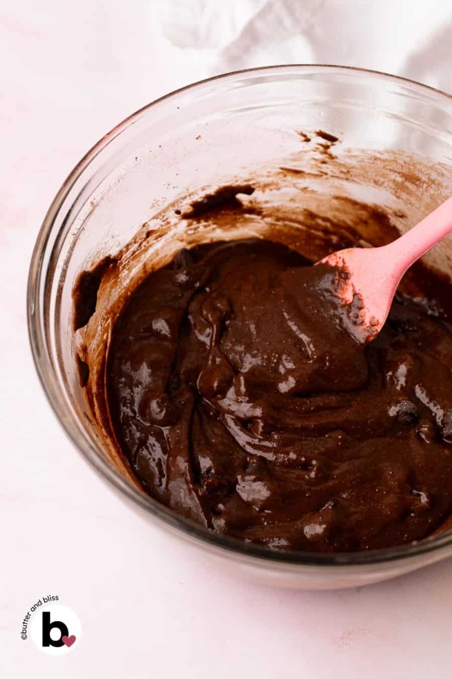 Bowl of fudgy chocolate crinkle cookie dough with a pink spatula.