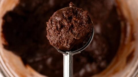 Fudgy chocolate crinkle cookie dough in a cookie scoop.