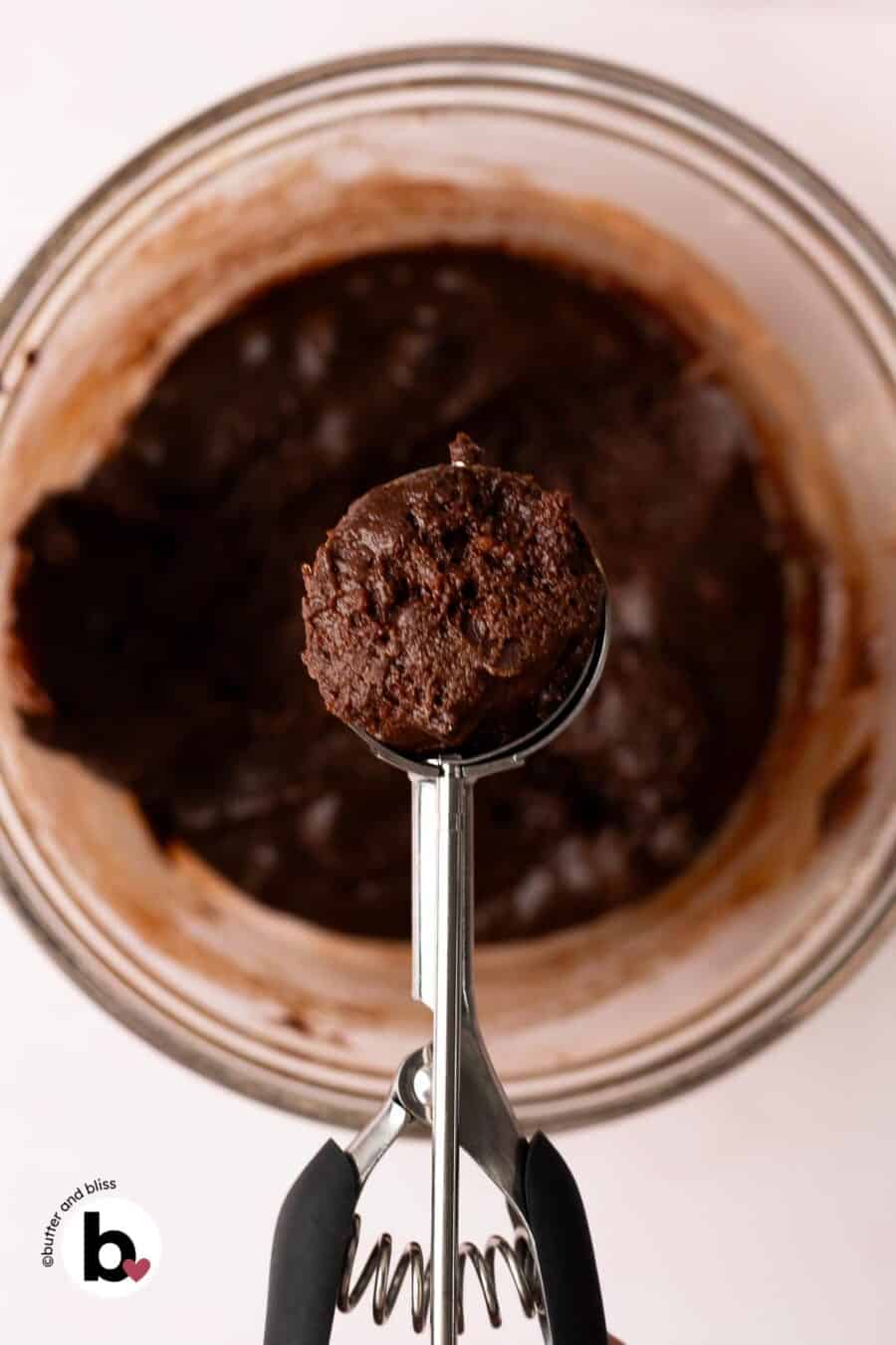 Fudgy chocolate crinkle cookie dough in a cookie scoop.