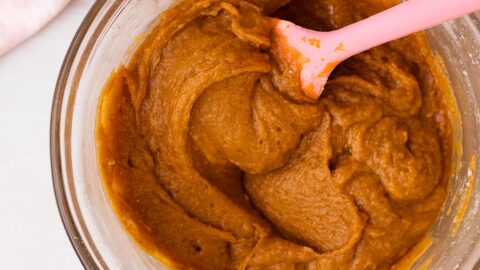 Pumpkin whoopie pie batter in a mixing bowl with a pink spatula.