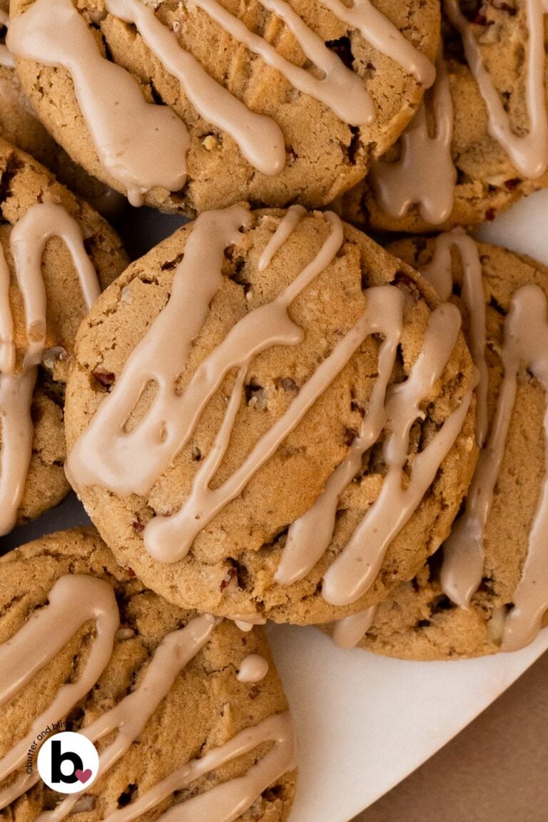 A stack of maple brown sugar cookies with maple icing on a white plate.