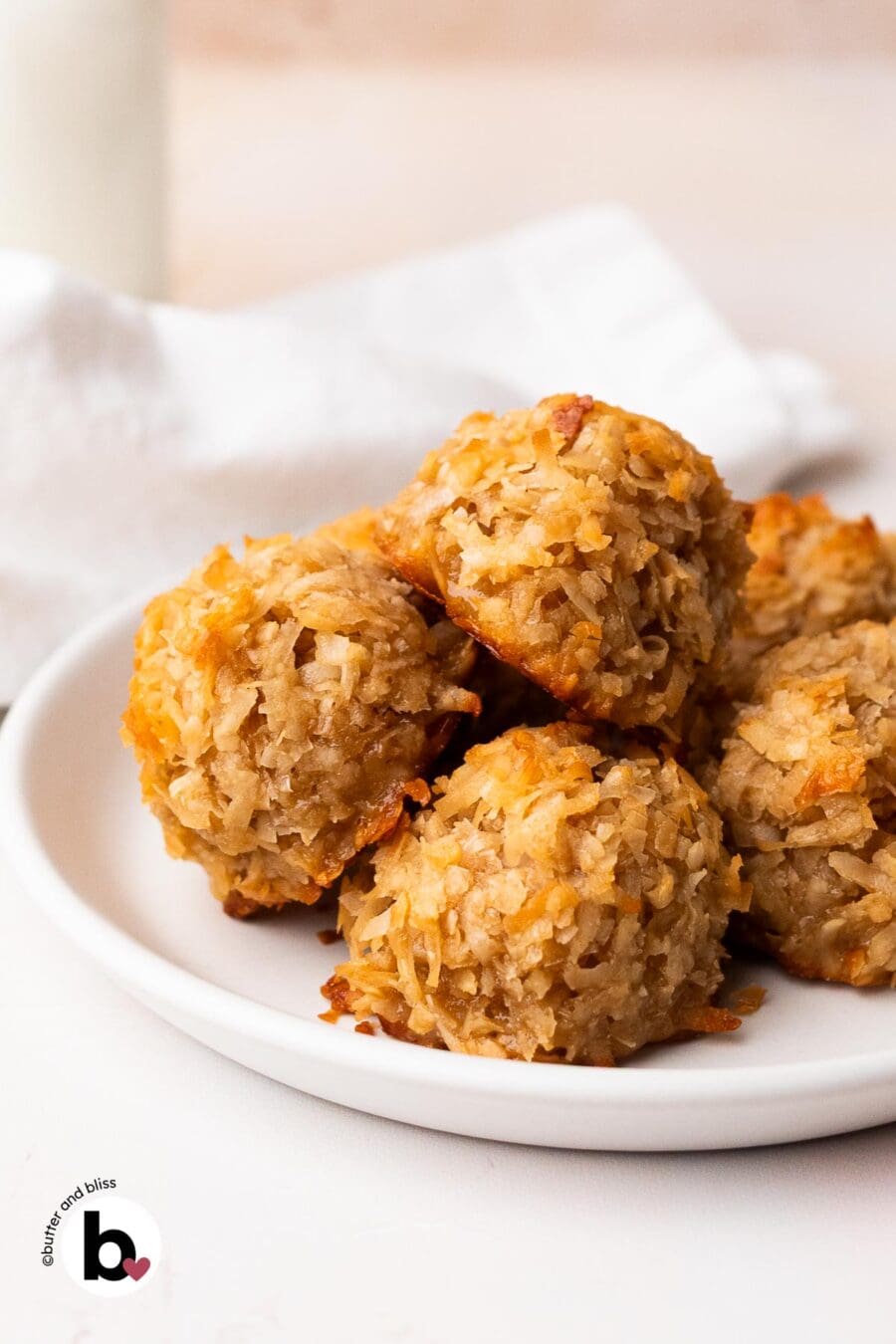 Toasted coconut maple macaroons piled on a white plate.