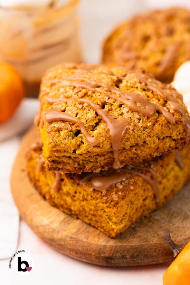 Pumpkin spice cinnamon scone with cinnamon drizzle on a wood plate.