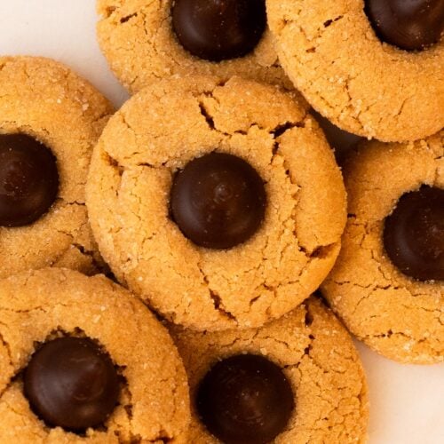 Small batch peanut butter blossoms stacked on a marble plate.