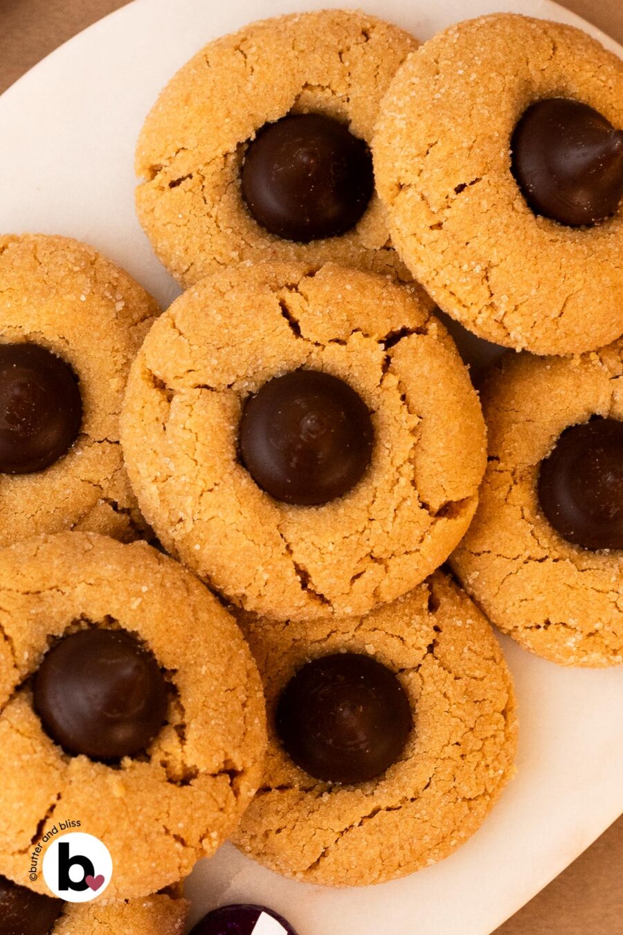 Small batch peanut butter blossoms stacked on a marble plate.