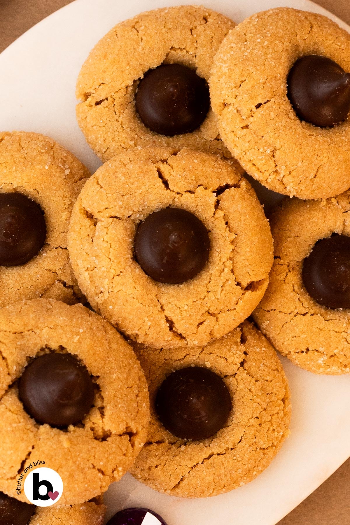 Small batch peanut butter blossoms stacked on a marble plate.